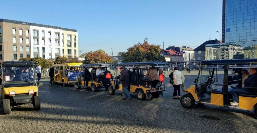 Krakow: Jewish Quarter and Ghetto Sightseeing Golf Cart Tour - Boarding the heated golf cart near Żabka